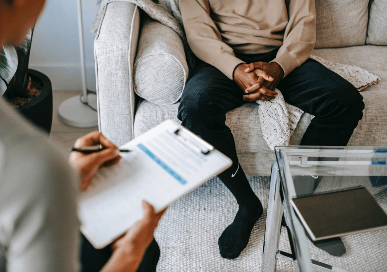 Empathetic clinician at Pothos Health discussing therapy options with a male client