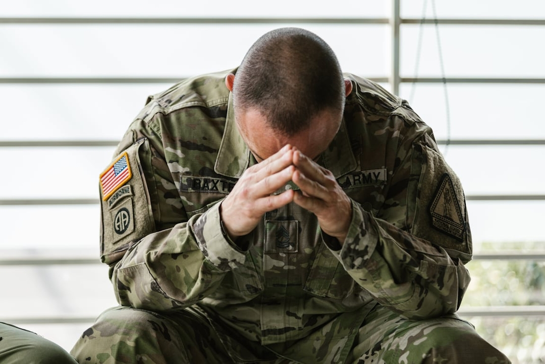 Soldier with heads downn in hand showing signs of PTSD